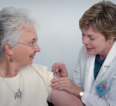 woman inject a woman on left shoulder